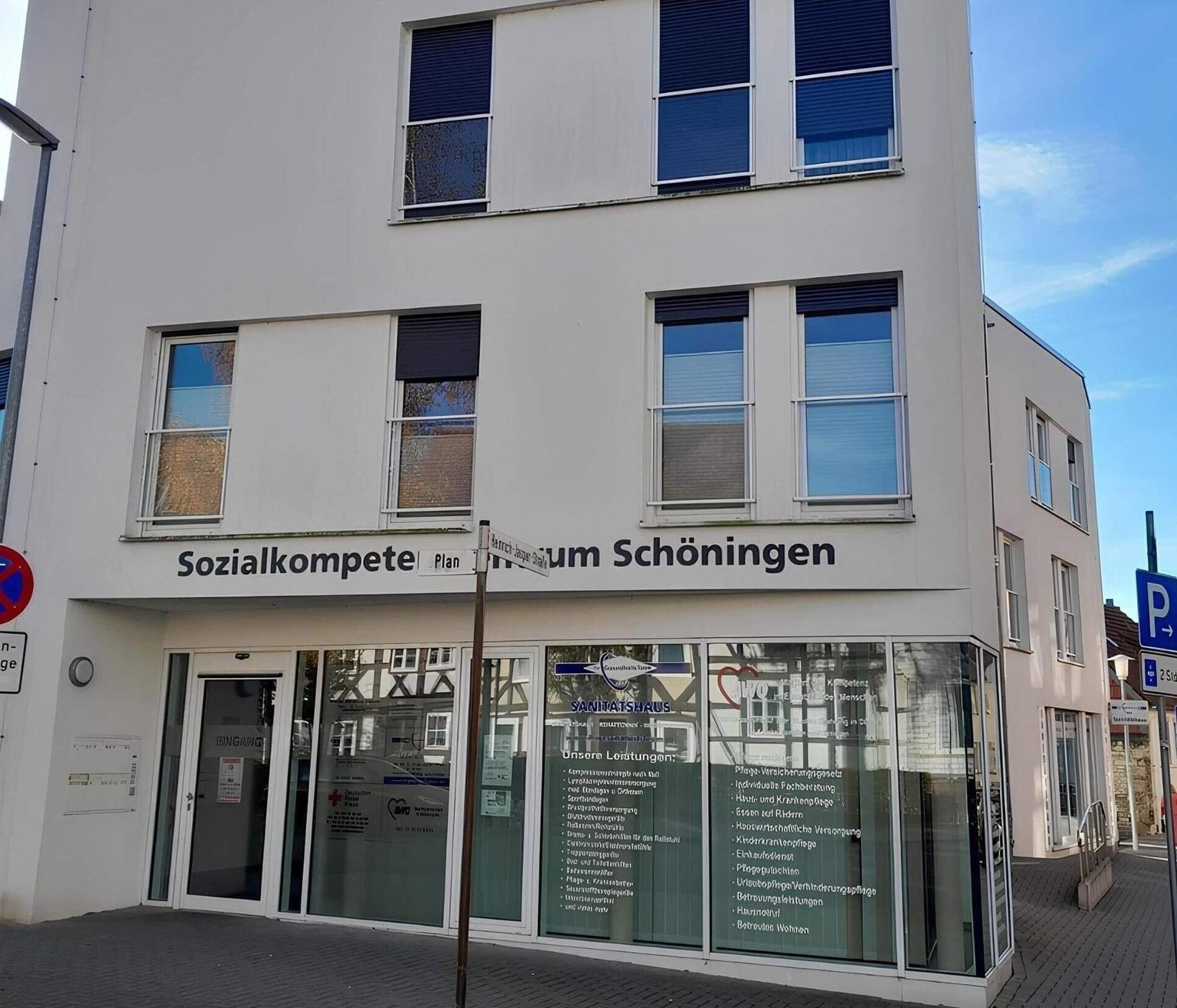 Eckgebäude mit großen Fenstern und Schriftzug 'Sozialkompetenzzentrum Schöningen' über dem Eingang